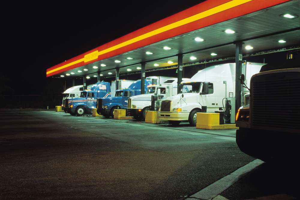 Semi trucks at fuel stop at night